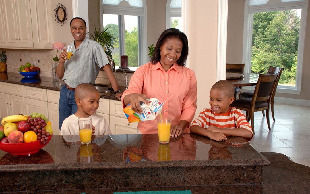 A family in a kitchen practices home safety while sheltering in place