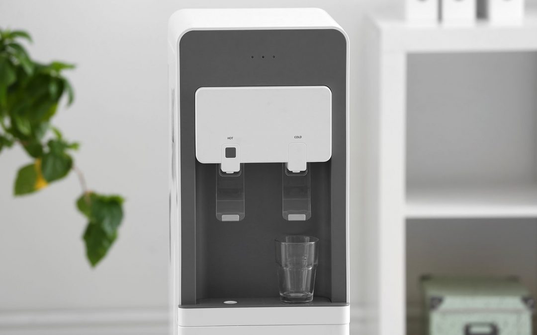 Modern water cooler with glass against blurred background
